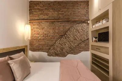 a bedroom with a brick wall and a bed at Suite San Calisto Trastevere - by romanhouseit in Rome