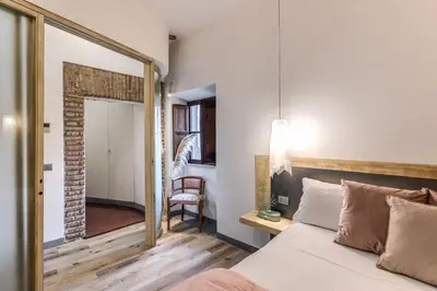 a bedroom with a bed with a mirror and a chair at Suite San Calisto Trastevere - by romanhouseit in Rome