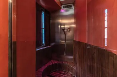 a bathroom with a shower with a red wall at Suite San Calisto Trastevere - by romanhouseit in Rome