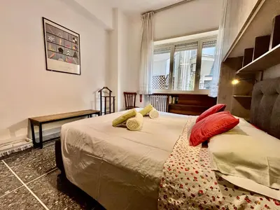 a bedroom with a bed with red and yellow pillows at San Pietro Intero Alloggio -PANE&MELE- in Rome