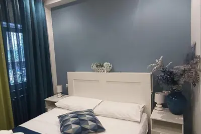 a bedroom with a white bed with a pillow on it at Il giardino di Marimar in Rome