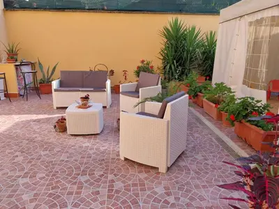 a patio with chairs and a table and plants at Il giardino di Marimar in Rome