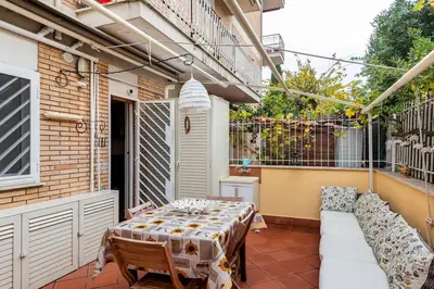 a patio with a table and chairs on a balcony at La Casudda di Ro' - metro A Battistini in Rome