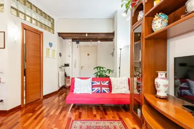 a living room with a pink couch and a tv at La Casudda di Ro' - metro A Battistini in Rome