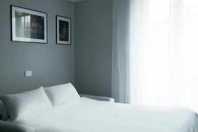 a white bedroom with a bed and a window at Basilica San Paolo - Home Cinema e Vasca Idromassaggio in Rome
