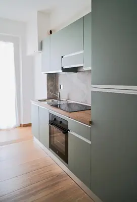 a kitchen with white cabinets and a sink at Basilica San Paolo - Home Cinema e Vasca Idromassaggio in Rome