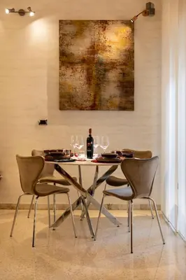 a table with chairs and a bottle of wine on it at Rome Elements Apartment in Rome