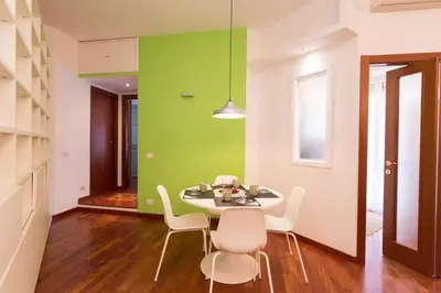 a dining room with a green wall and a table and chairs at Podesti House - Flaminio Stadio Olimpico in Rome