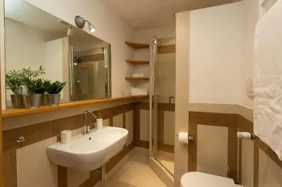 a bathroom with a sink and a toilet and a mirror at Podesti House - Flaminio Stadio Olimpico in Rome