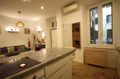 a kitchen with a counter top and a living room at Testaccio Holiday House in Rome