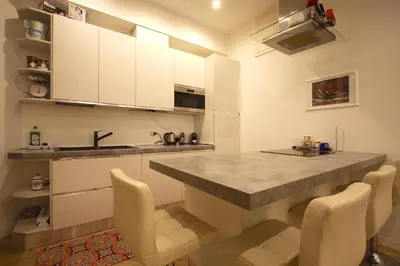a kitchen with a large counter and white cabinets at Testaccio Holiday House in Rome