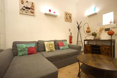 a living room with a gray couch with colorful pillows at Testaccio Holiday House in Rome