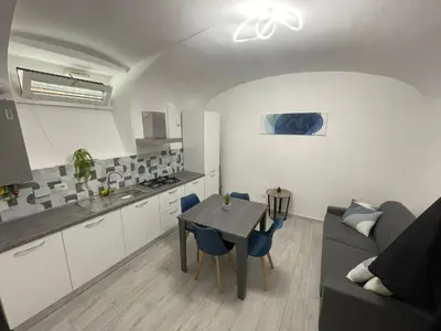 a kitchen and living room with a table and a couch at TrastevereLoft228 Apt. WHITE in Rome