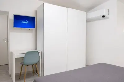 a bedroom with a desk and a blue chair at TrastevereLoft228 Apt. WHITE in Rome