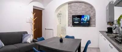 a kitchen and living room with a table and a couch at TrastevereLoft228 Apt. WHITE in Rome