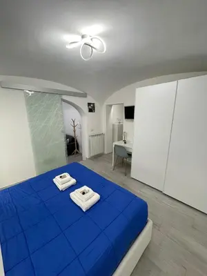 a bedroom with a blue bed with towels on it at TrastevereLoft228 Apt. WHITE in Rome