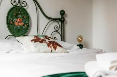 a white bed with a green headboard and a white pillow at Giava Home in Rome