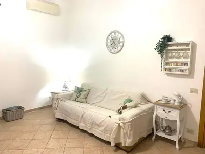 a living room with a white couch and a clock on the wall at Giava Home in Rome