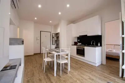 a kitchen with white cabinets and a table and chairs at Salotti 15 in Rome