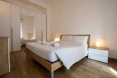 a bedroom with a large white bed with two lamps at Salotti 15 in Rome