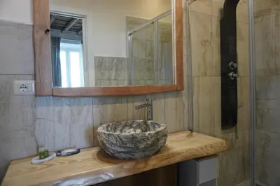 a bathroom with a stone sink and a mirror at Penna Relais al Corso in Rome