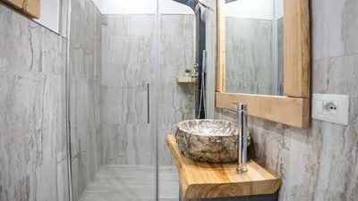 a bathroom with a stone sink and a shower at Penna Relais al Corso in Rome