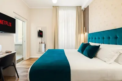 a hotel room with a large bed with a blue headboard at AlbaDea Déco&Jacuzzi in Rome