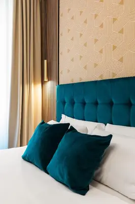 a bed with a blue headboard and two blue pillows at AlbaDea Déco&Jacuzzi in Rome