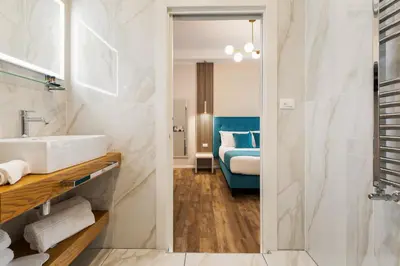 a bathroom with a sink and a bedroom at AlbaDea Déco&Jacuzzi in Rome