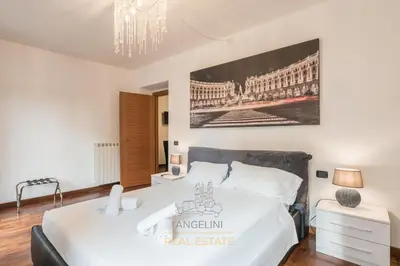 a bedroom with a large white bed and a chandelier at Apartment by The Spanish Steps in Rome