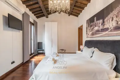 a bedroom with a large bed and a chandelier at Apartment by The Spanish Steps in Rome