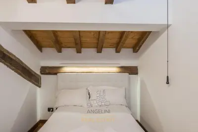 a white bed in a room with wooden ceilings at Apartment by The Spanish Steps in Rome