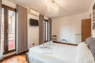 a room with a white bed with a chandelier at Apartment by The Spanish Steps in Rome