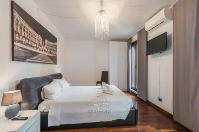 a white bedroom with a bed and a chandelier at Apartment by The Spanish Steps in Rome