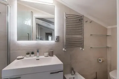 a bathroom with a white sink and a mirror at The Best Rent - Apartment near Castel Sant'Angelo in Rome