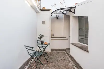 a small table and chairs on a patio in a building at The Best Rent - Apartment near Castel Sant'Angelo in Rome