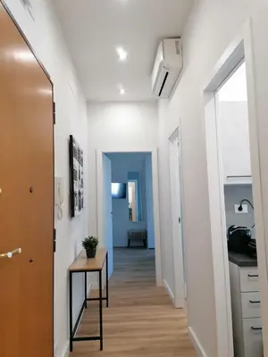 a hallway with white walls and a table in a room at Capitale Bullicante in Rome