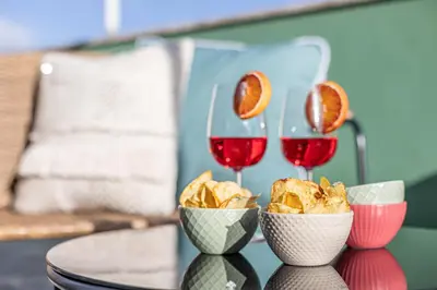 a table with two glasses of wine and nachos at Viola Penthouse with Rome Panoramic View in Rome