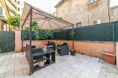 a patio with an umbrella and a table at The vatican garden in Rome