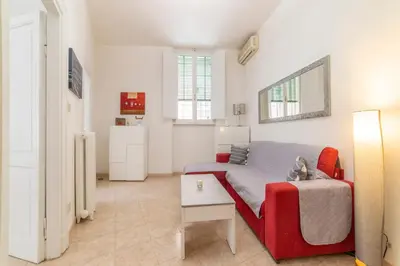 a living room with a red couch and a table at The vatican garden in Rome