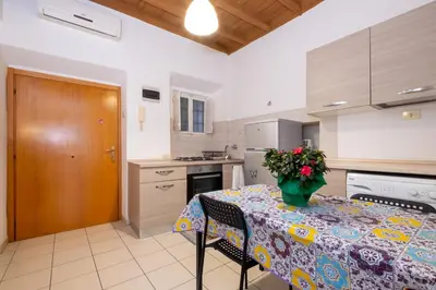 a kitchen with a table with a vase of flowers on it at HT BILO 2 COLOSSEO in Rome