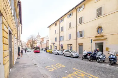 a street with cars and motorcycles parked next to buildings at HT BILO 2 COLOSSEO in Rome