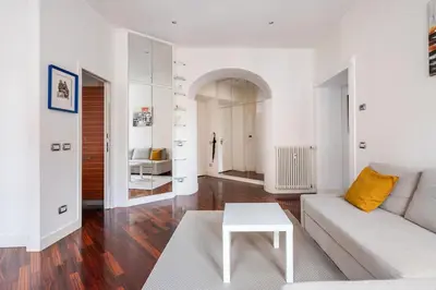 a white living room with a couch and a table at La corte di Merlino - Apt centrale di pregio in Rome