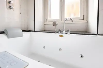 a white bath tub with a sink and a window at La corte di Merlino - Apt centrale di pregio in Rome