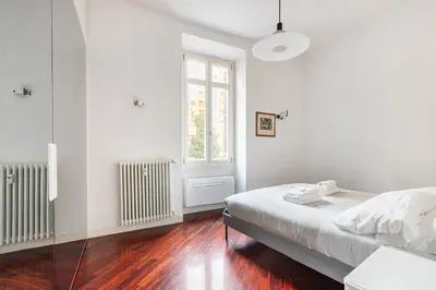 a white bedroom with a bed and a window at La corte di Merlino - Apt centrale di pregio in Rome