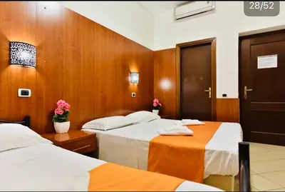 two beds in a room with wood paneling at TERMINI STAR in Rome