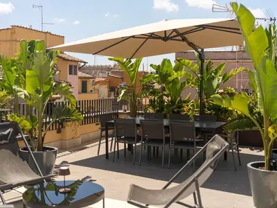 a patio with tables and chairs and an umbrella at LUXURY Terrazza Privata su Fontana di Trevi in Rome