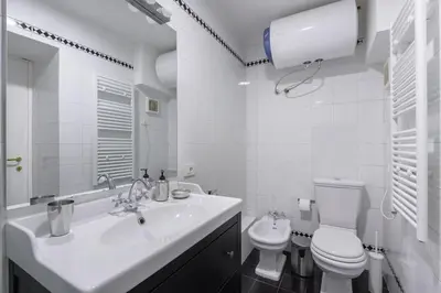 a white bathroom with a sink and a toilet at Discover the Pantheon from The Berardi Studio Flat in Rome