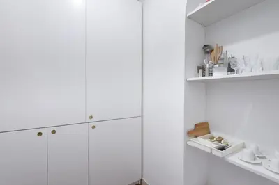 a white kitchen with white cabinets and a shelf at Discover the Pantheon from The Berardi Studio Flat in Rome