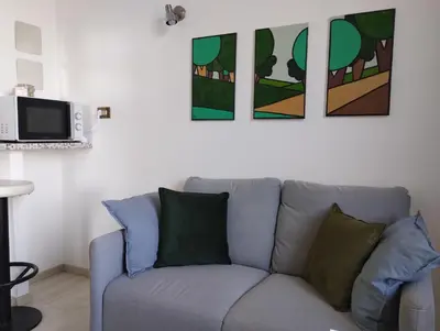 a couch in a living room with paintings on the wall at La Casa nel Parco - Stadio Olimpico, Auditorium con posto auto in Rome